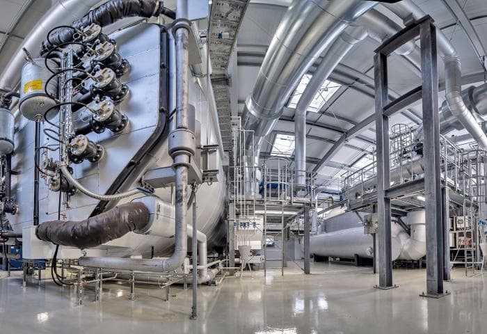 Technician applying insulation to industrial piping